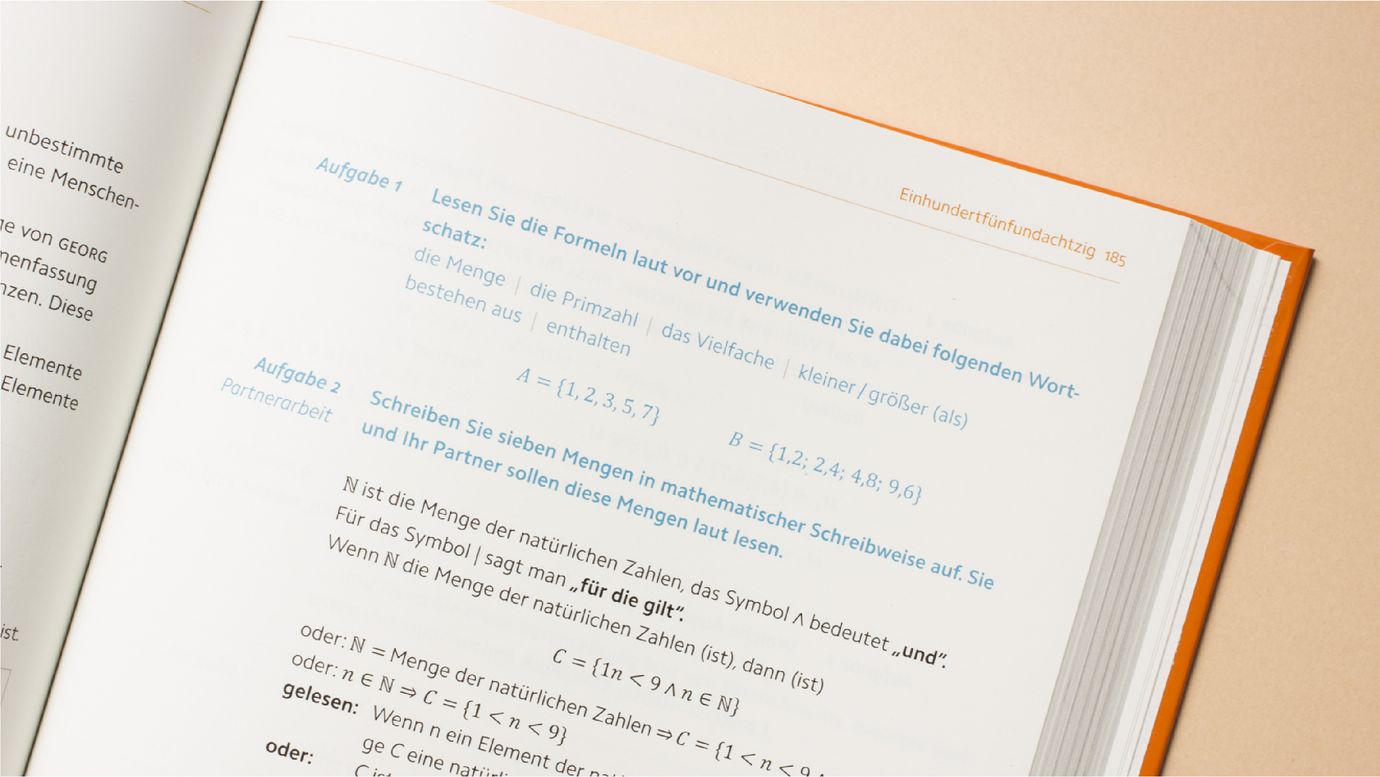 An open page of a German language textbook reveals visible text and mathematical formulas.